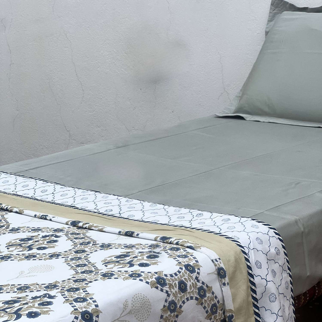 Floral patterned quilt on a bed with a neutral background