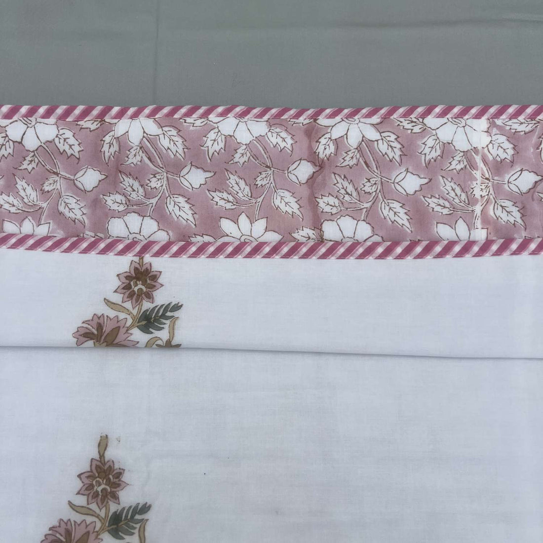 Floral patterned fabric with pink and white flowers on a striped background