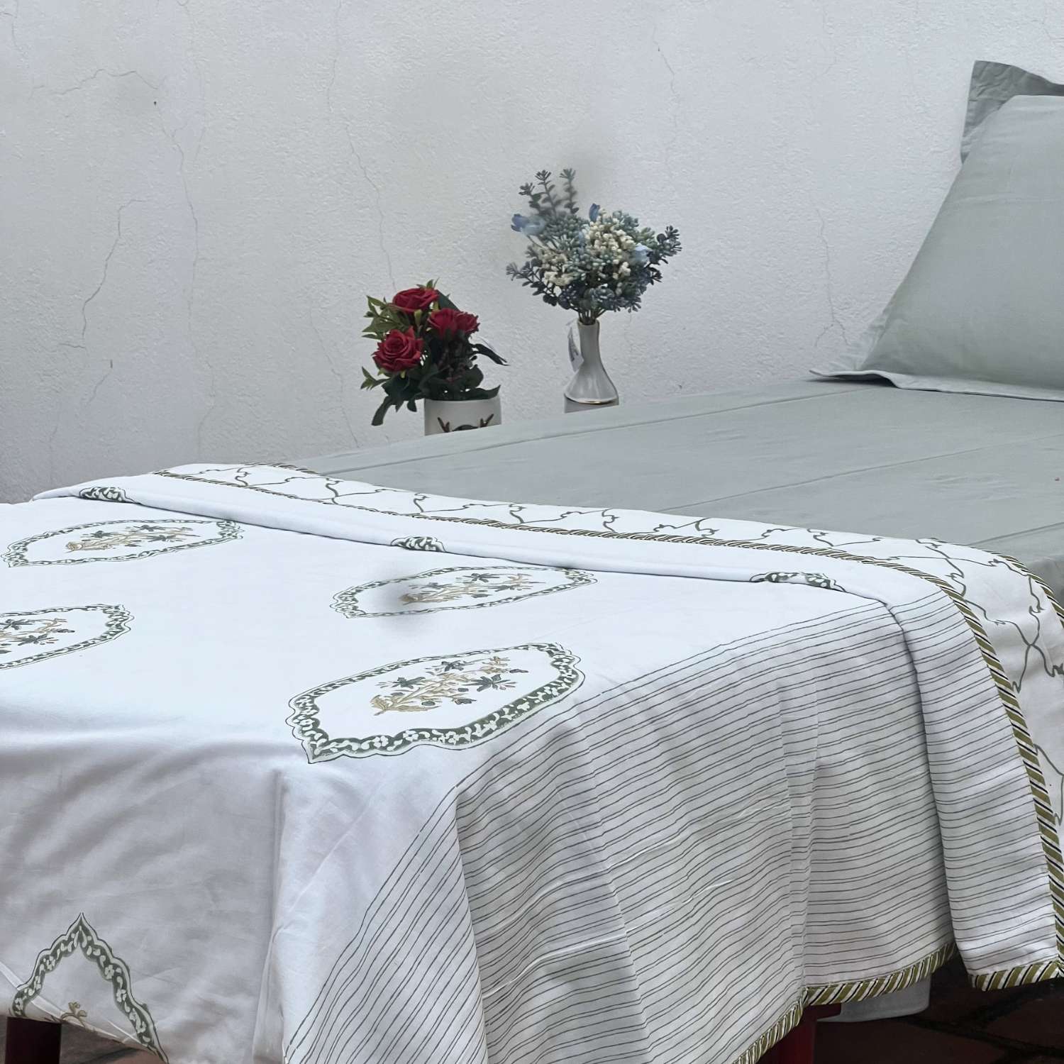 White fabric with green and brown embroidery on a white background