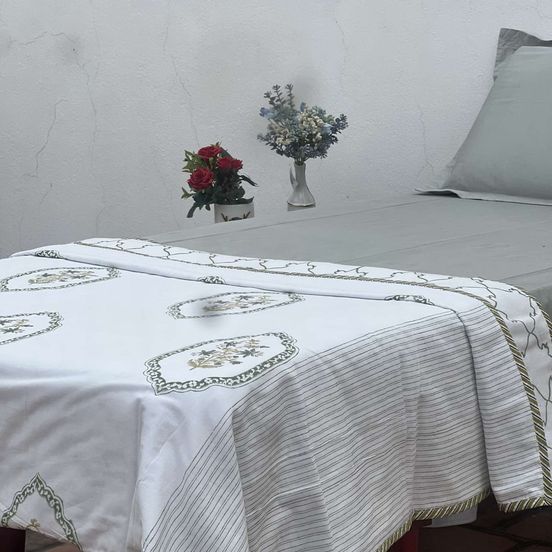 White fabric with green and brown embroidery on a white background